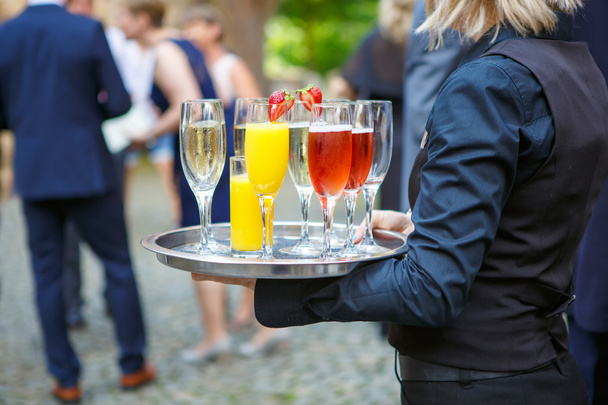 camarera con una bandeja de vasos de diferentes bebidas en la boda
 - Foto, imagen