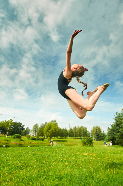 Young beautiful preteen girl doing gymnastics outdoors - Photo, Image