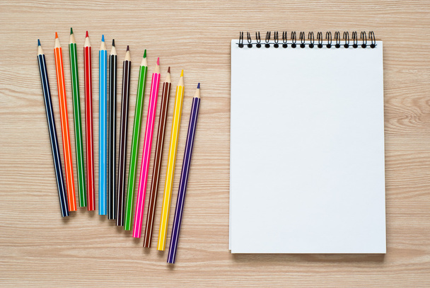 Crayons et cahier sur un bureau
. - Photo, image