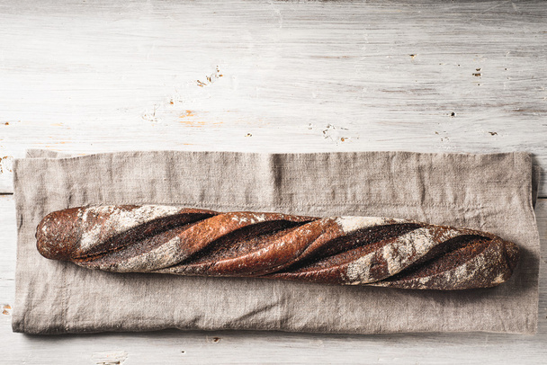 Baguette on the napkin on the white wooden table horizontal - Photo, image