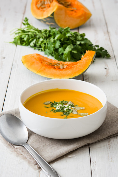 Pumpkin soup and ingredients on a white wooden table - Photo, Image