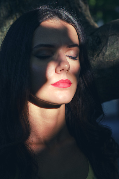 Portrait of beautiful sad girl hiding in shadows on sunny summer - Zdjęcie, obraz