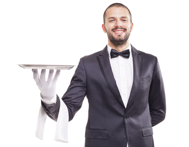 Smiling waiter holding an empty silver tray - Фото, изображение
