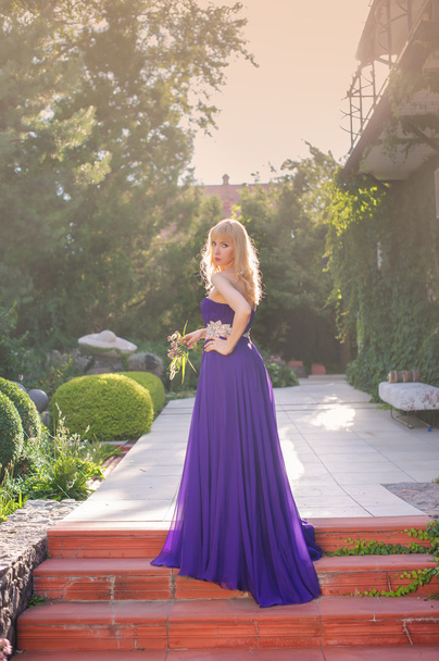 Жінка носить довгу фіолетову сукню
. - Фото, зображення