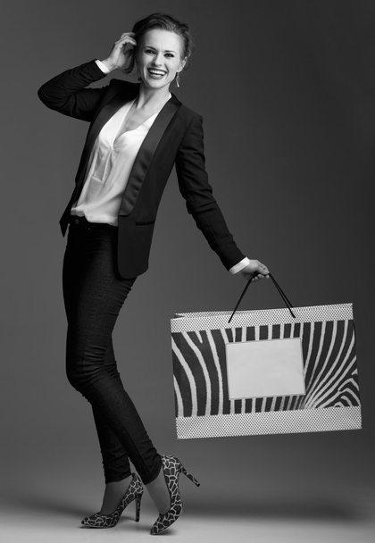 Happy woman with big shopping bag against grey background - Photo, Image