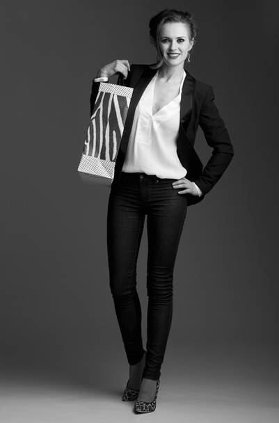 Happy elegant woman with shopping bag against grey background - Foto, Bild