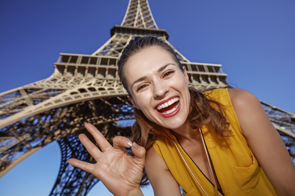 smiling woman showing ok gesture in front of Eiffel tower, Paris - Valokuva, kuva