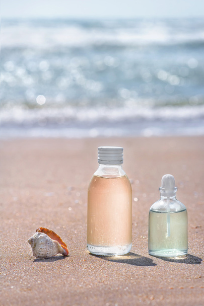 Bottles with oil essence and shell in the sea waves. Spa and wel - Photo, Image