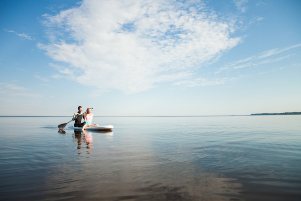 Young couple paddling on sup board - Fotó, kép