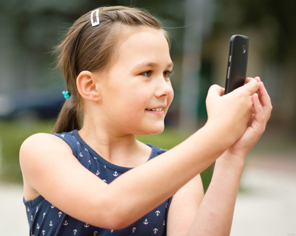 Girl is using smartphone - Foto, afbeelding