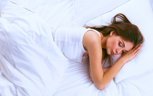 Beautiful girl sleeps in the bedroom, lying on bed - Foto, Imagem