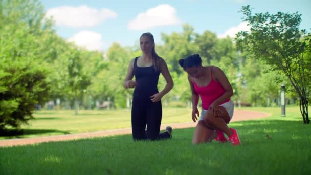 Фитнес-женщины готовятся к тренировке на открытом воздухе. Многорасовая женщина дышит глубоко
 - Кадры, видео