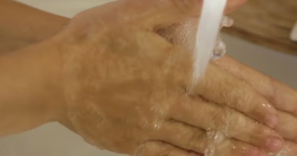 Κοντινό πλάνο της τα παιδιά χέρι κάτω από το ρεύμα του νερού στο μπάνιο σε αργή κίνηση - Πλάνα, βίντεο