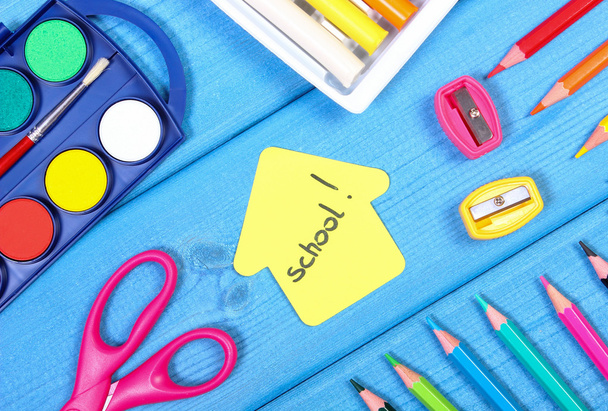 School accessories and shape of building on blue boards, back to school concept - Zdjęcie, obraz