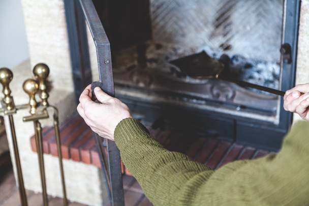 Homme nettoie la pelle cheminée en laiton
 - Photo, image