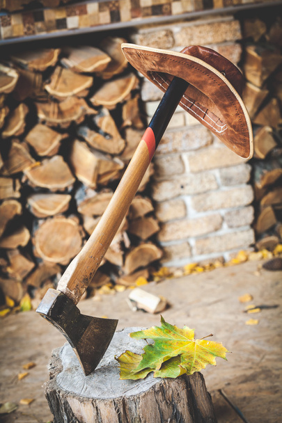 hat hanging on handle ax, which juts out into stump - 写真・画像