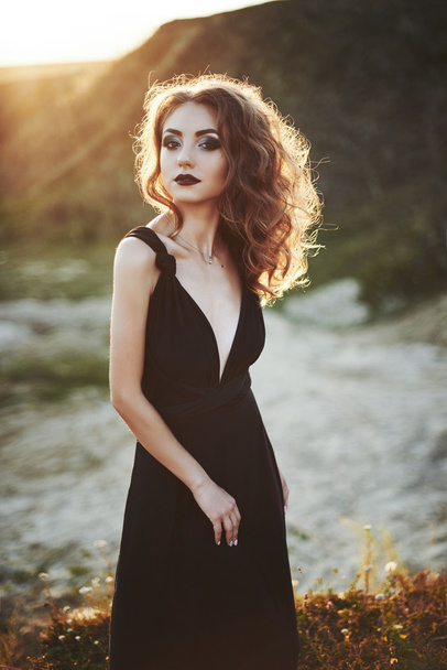 Fashion shot of the elegant young woman posing over beautiful landscape. - Fotografie, Obrázek