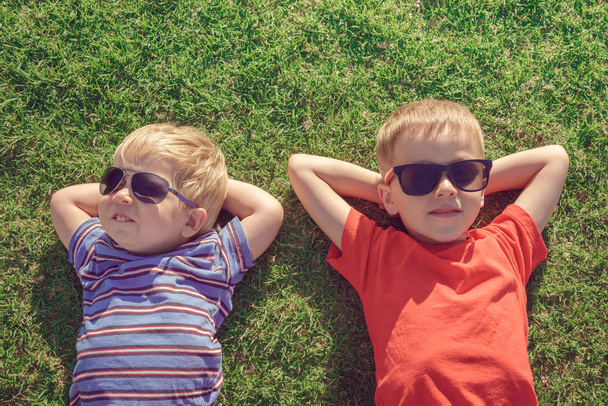 Enfants se relaxant sur l'herbe
  - Photo, image