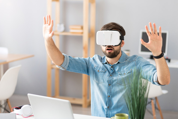 Emotional man using virtual reality glasses - 写真・画像