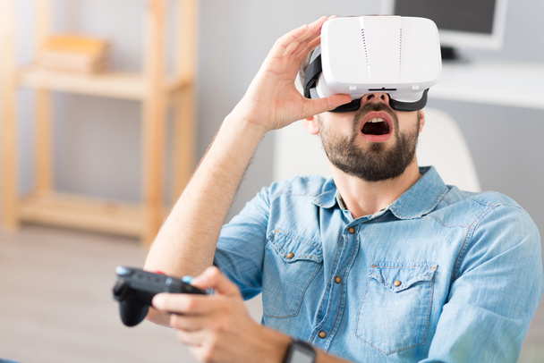 Surprised man using virtual reality glasses - Фото, зображення