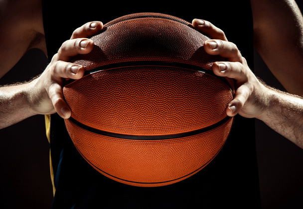 Silhouette view of a basketball player holding basket ball on black background - 写真・画像