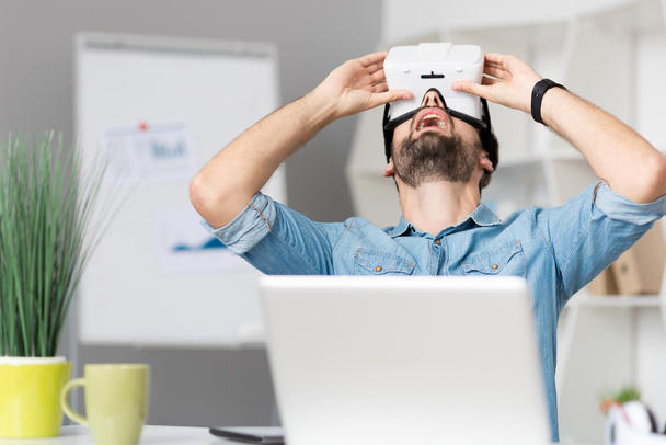 Pleasant man using virtual reality glasses - Fotó, kép