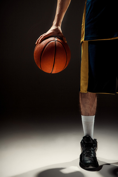 Silhouette view of a basketball player holding basket ball on black background - Φωτογραφία, εικόνα