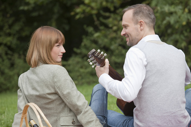 ピクニックでギターを弾く男 - 写真・画像