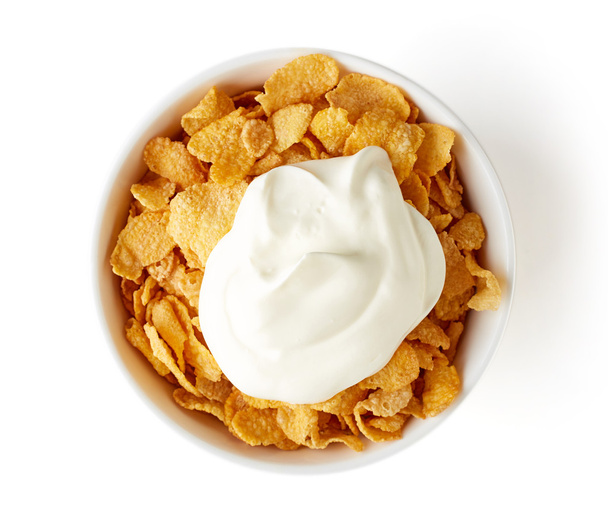Кукурузные хлопья миска с йогуртом изолированы на белом, сверху
 - Фото, изображение