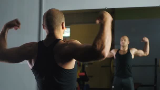 Сильный спортсмен демонстрирует мышцы перед зеркалом
. - Кадры, видео