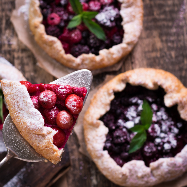 Blueberry,cherry,raspberry and blackcurrant galette on w wooden background. - Foto, afbeelding