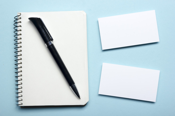 Business card blank over notepad at office table. Corporate stationery branding mock-up - 写真・画像