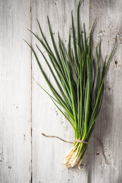 Green onion on the white wooden table top view - Foto, Imagem