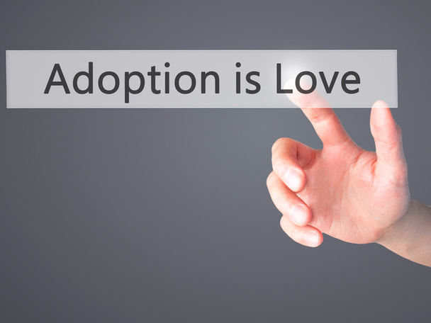 Adoption ist Liebe - Hand drückt einen Knopf auf verschwommenem Hintergrund  - Foto, Bild