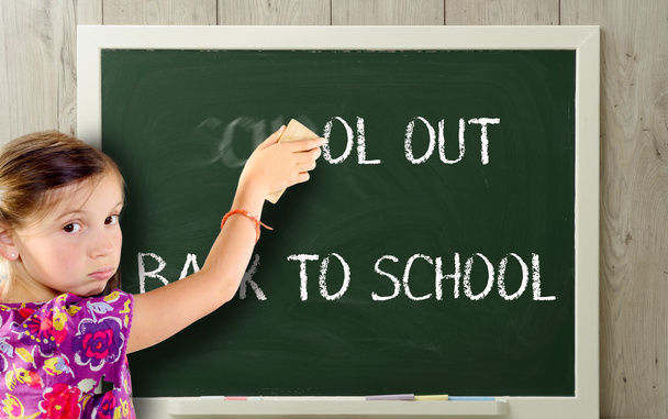 uma menina limpa a escola no quadro negro
 - Foto, Imagem