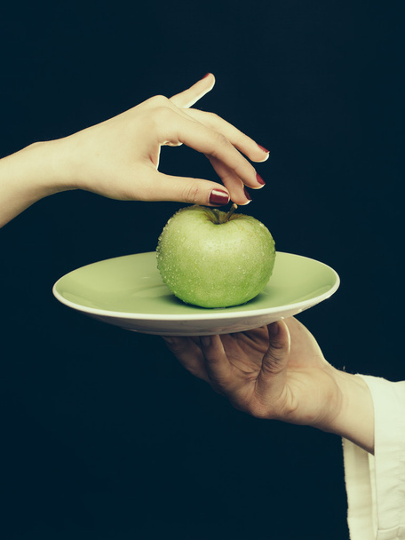Green apple on plate in hand - Fotografie, Obrázek