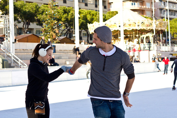 Молодая пара катается на коньках вместе и веселится
 - Фото, изображение