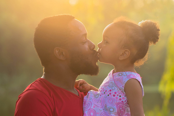 Père africain embrassant et embrassant une fille de bébé
.  - Photo, image