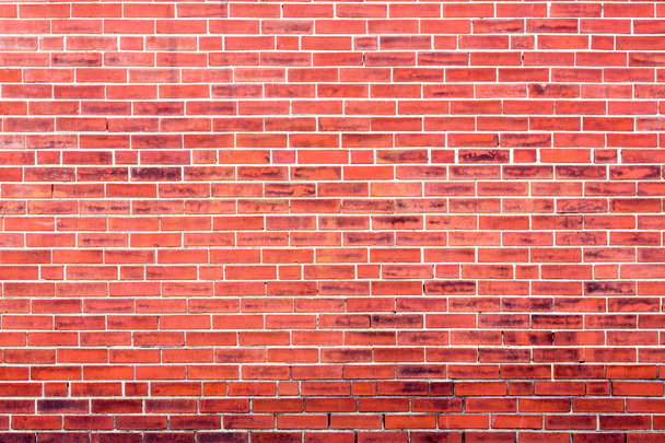 Bright red brick wall background with dark stains - Photo, Image