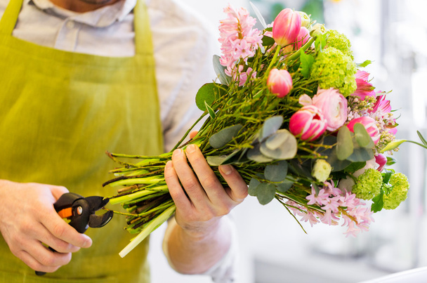 close up of florist man with flowers and pruner - Foto, Bild