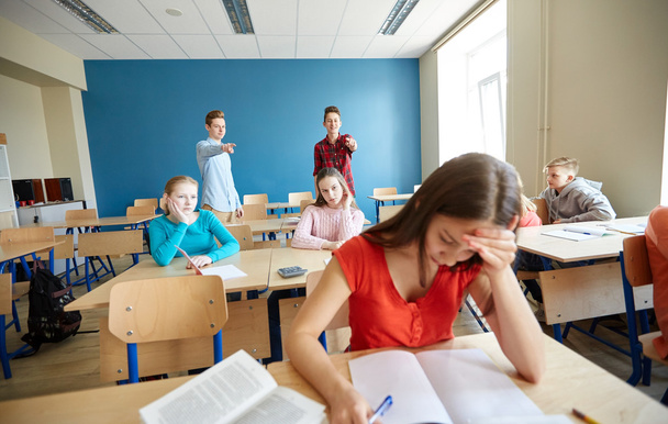 students gossiping behind classmate back at school - Zdjęcie, obraz