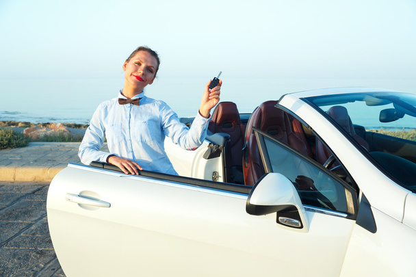 Young woman standing near a convertible with keys in hand - Photo, Image