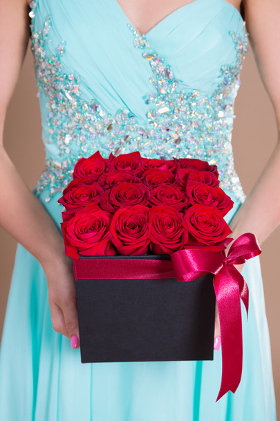 close up of box with red rose flowers in female hands - Foto, imagen