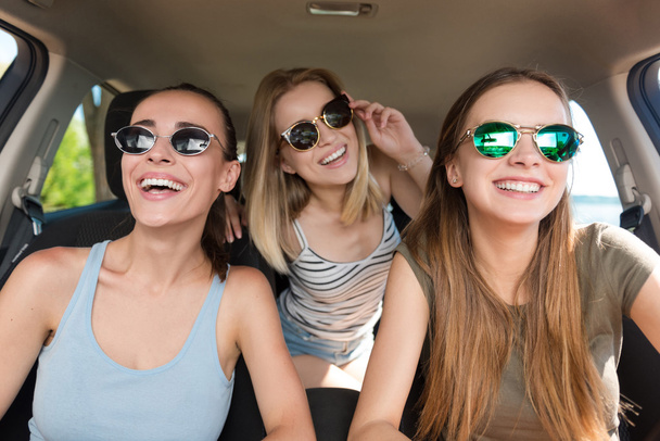 Positive smiling friends driving a car - Photo, image