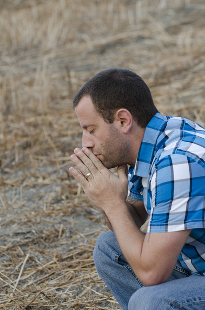 Hombre rezando solo en una ladera
 - Foto, imagen