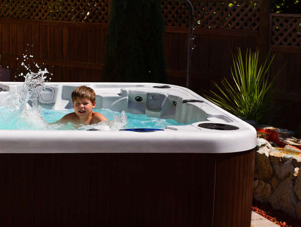 Happy boy playing in jacuzzi on the back yard - Photo, Image