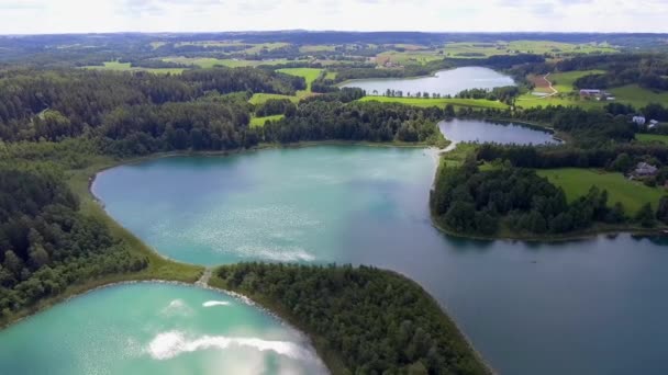 マズリア、ポドラシェ県地区、ポーランドの湖の小さな島の眺め。青い水と白の雲。夏の時間。上からの眺め. - 映像、動画