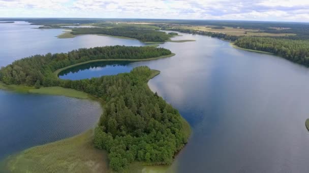 Masuria ve Podlasie bölgesinde, Polonya göl kenarında küçük adalar manzarası. Mavi su ve beyaz bulutlar. Yaz saati. Yukarıdan görüntülemek. - Video, Çekim