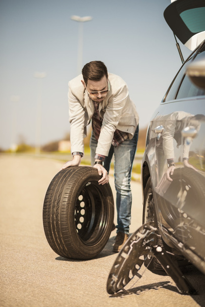 Changing tire on broken car on road - Zdjęcie, obraz