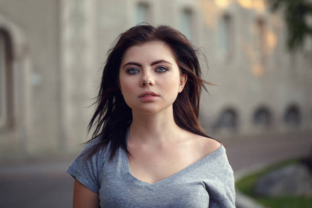 Closeup portrait of beautiful young sexy Caucasian woman with red black hair, blue eyes, looking in camera, outdoors on sunset, summer evening, natural beauty youth look - Photo, Image